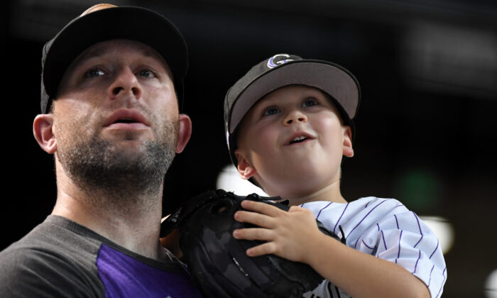 A father and son watch batting practice prior to a game between the Colorado Rockies and Arizona Diamondbacks at Chase Field on August 20, 2019 in Phoenix, Arizona. (Photo by Norm Hall/Getty Images)